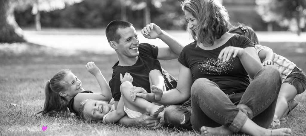 Portrait de famille pleine de complicité en extérieur